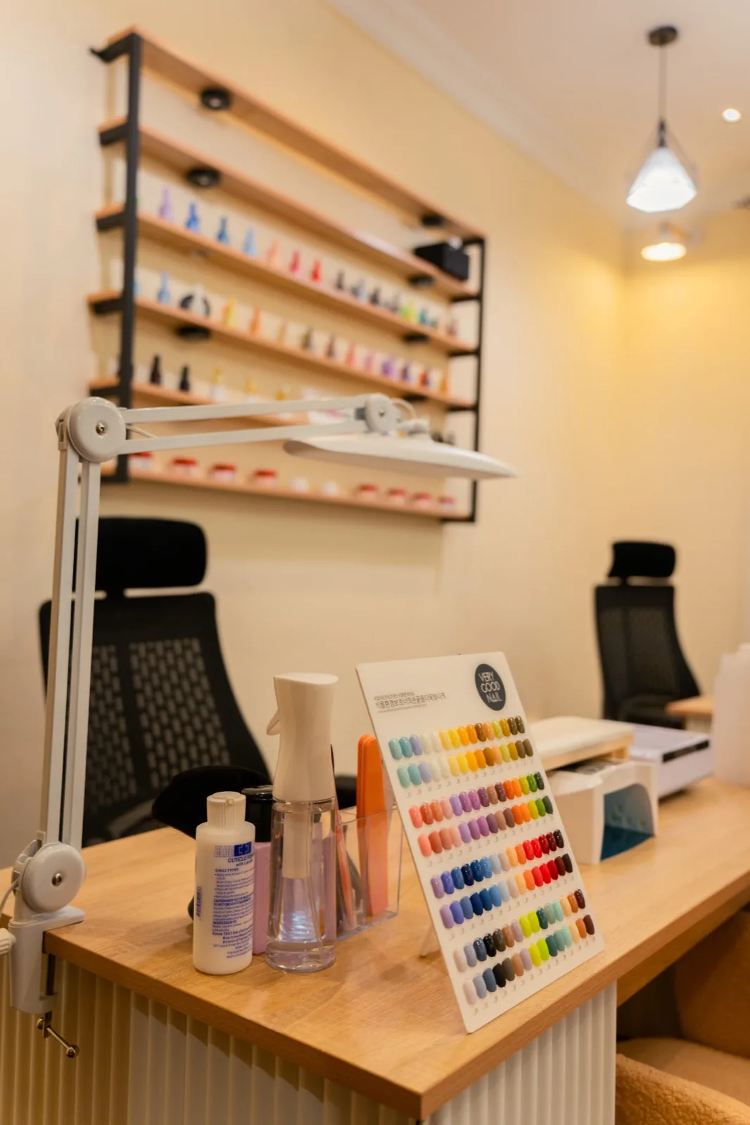 Shelves of nail polish and a gel colour chart at the studio